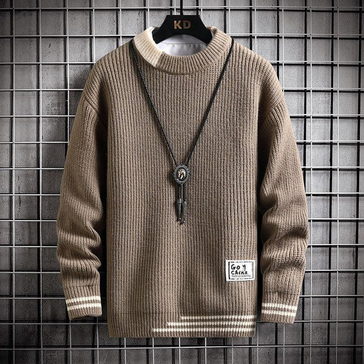 Brown ribbed knit sweater with beige collar and stripes, hanging on black hanger against metal grid background