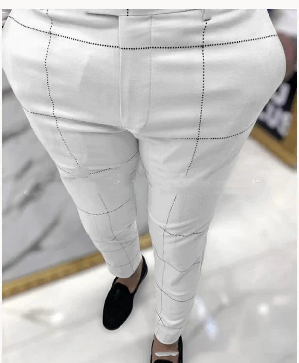 White slim-fit trousers with black windowpane check pattern worn with black loafers on marble floor