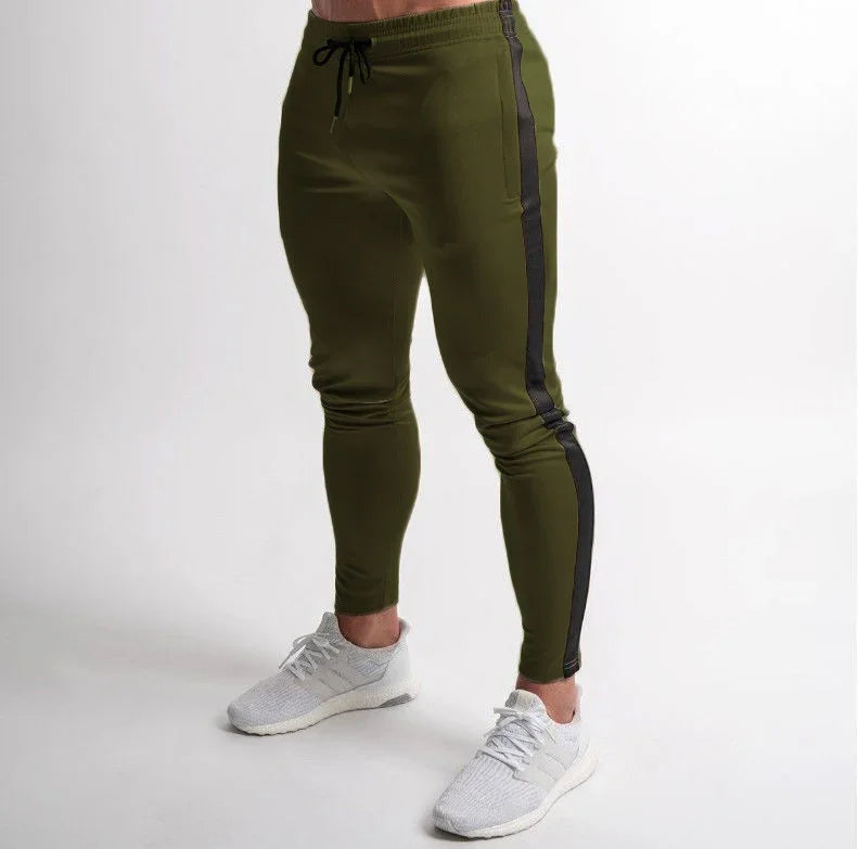Close-up of olive green slim-fit jogger pants with black side stripe worn with white athletic shoes