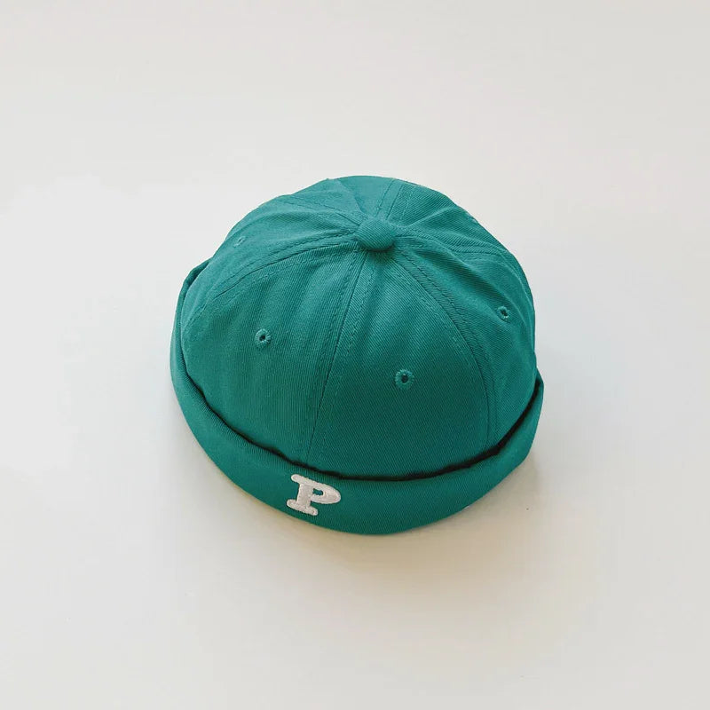 Teal fabric beanie cap with rolled brim and white letter P embroidery on front