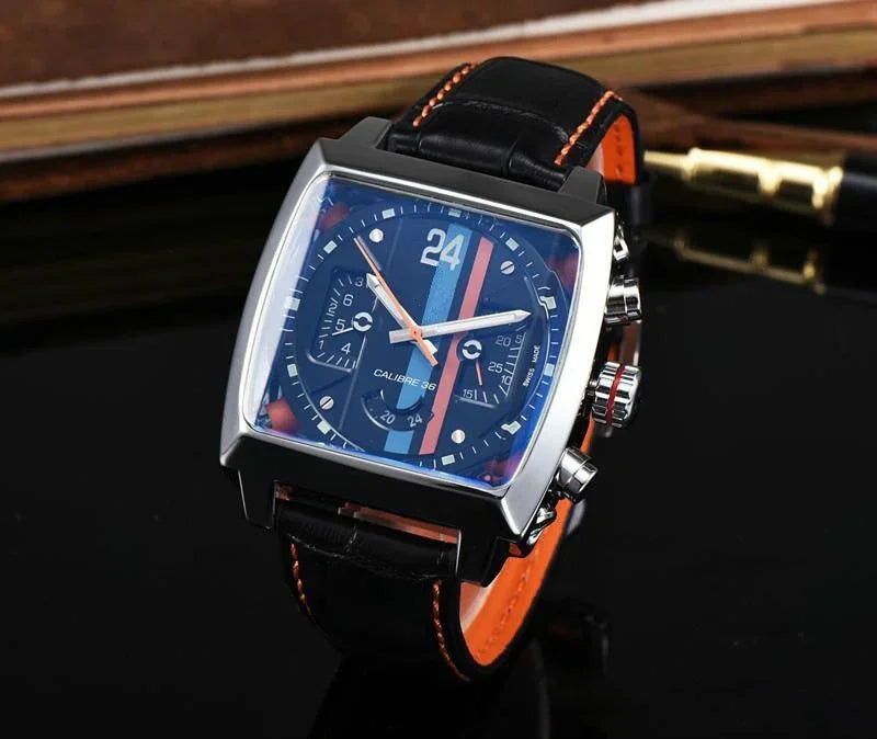 square wristwatch with black dial, blue and orange stripes, black leather strap with orange stitching