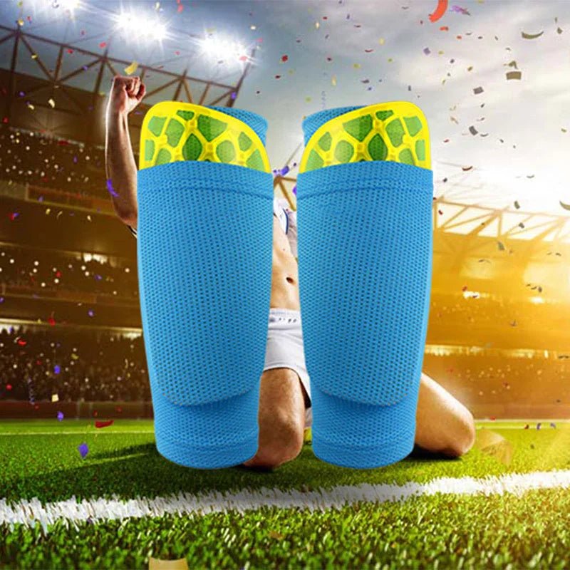 Blue soccer shin guards with yellow padding on a stadium field background