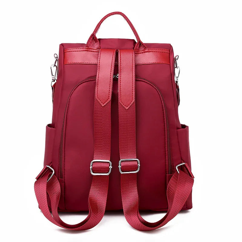 Stylish red backpack with adjustable shoulder straps and top handle on white background