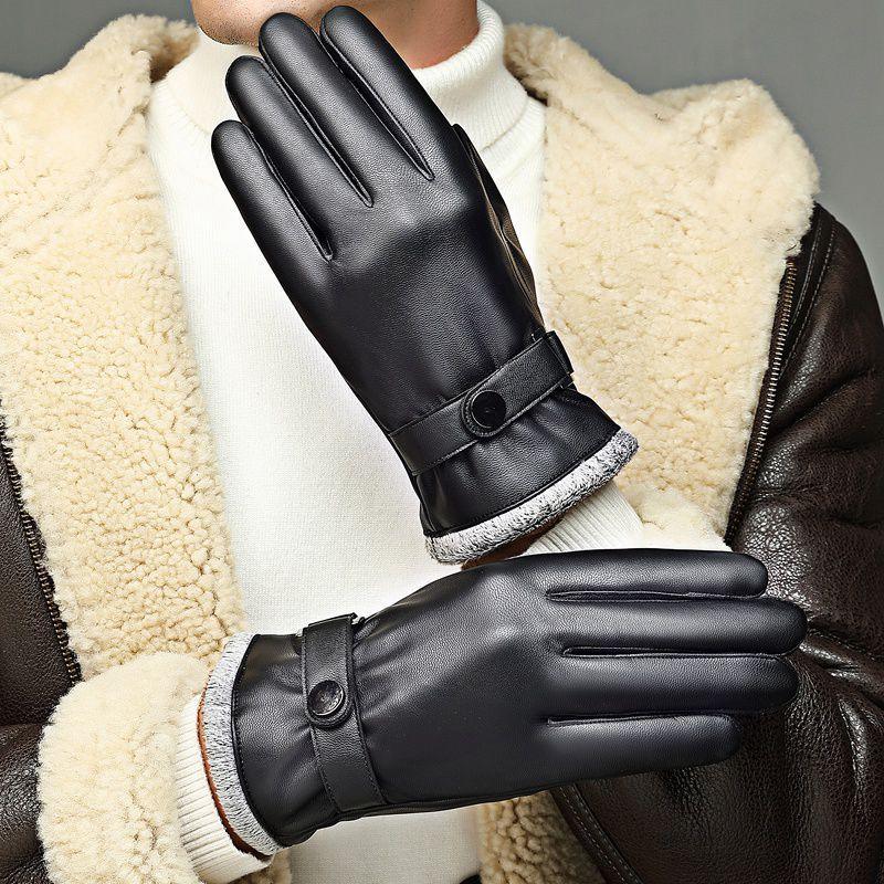 Close-up of man wearing black leather winter gloves with button straps and faux fur lining, paired with shearling jacket