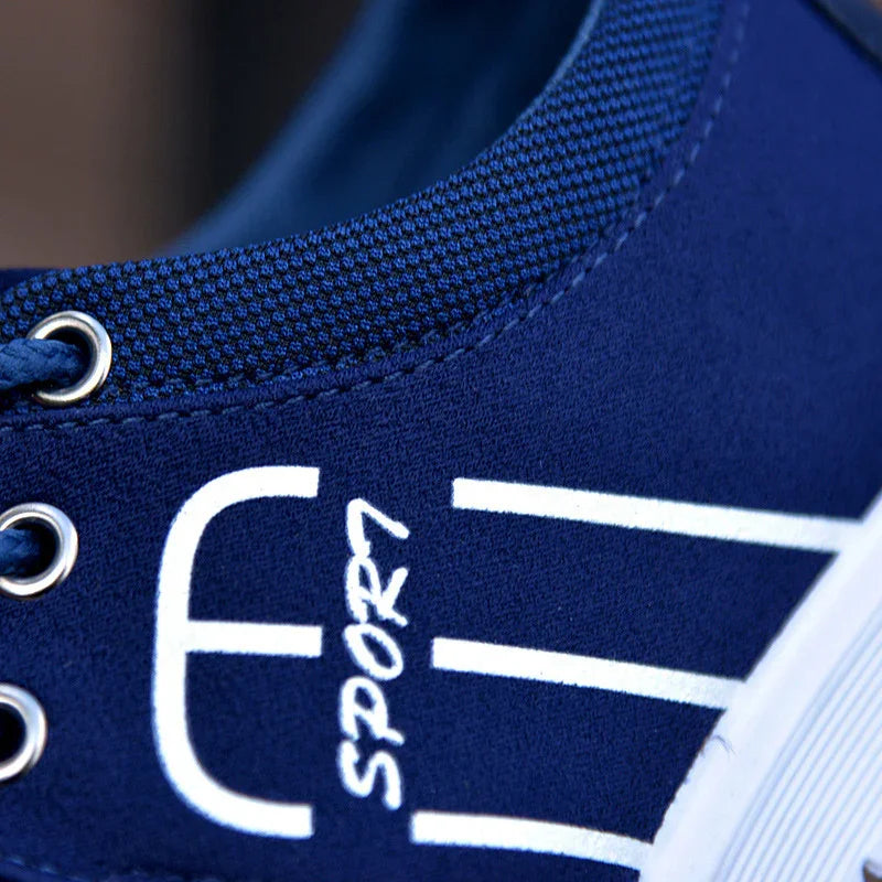 Close-up of blue sports sneaker with white graphic design and metal eyelets