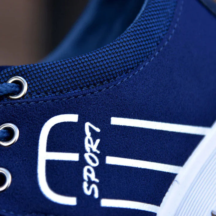 Close-up of blue sports sneaker with white graphic design and metal eyelets