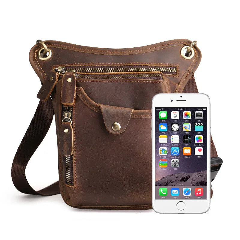 brown leather crossbody bag with multiple zippered pockets and a smartphone beside it