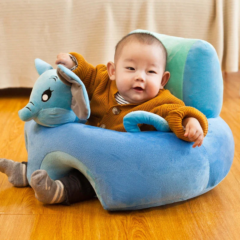 Baby sitting in a soft blue elephant-shaped plush seat on wooden floor