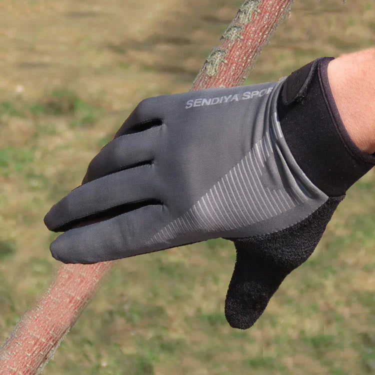Hand wearing black and gray SENDIYA SPORT glove holding a textured branch outdoors on grass