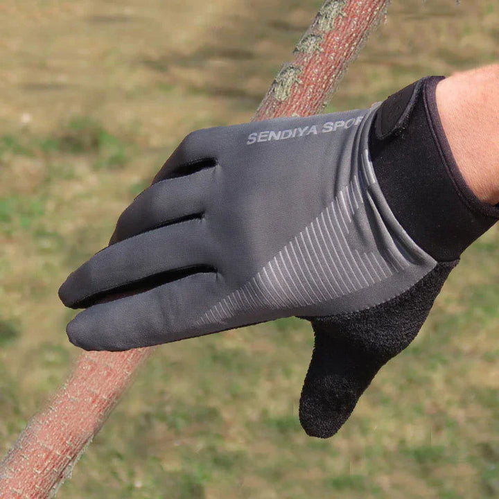 Hand wearing black and gray SENDIYA SPORT glove holding a textured branch outdoors on grass