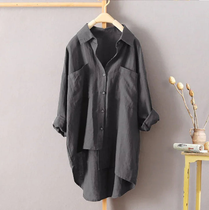 Dark gray oversized button-up shirt with rolled sleeves hanging on wooden hanger