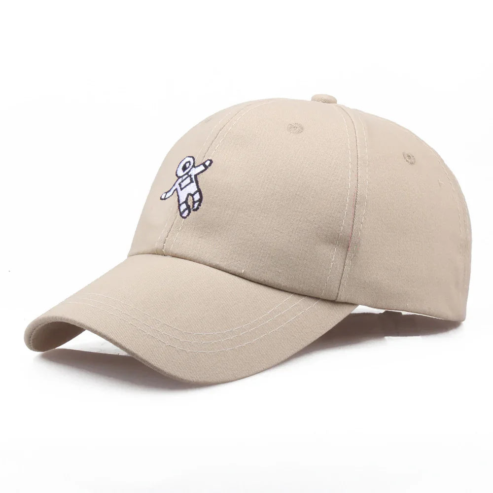 beige baseball cap with small embroidered astronaut patch on front panel