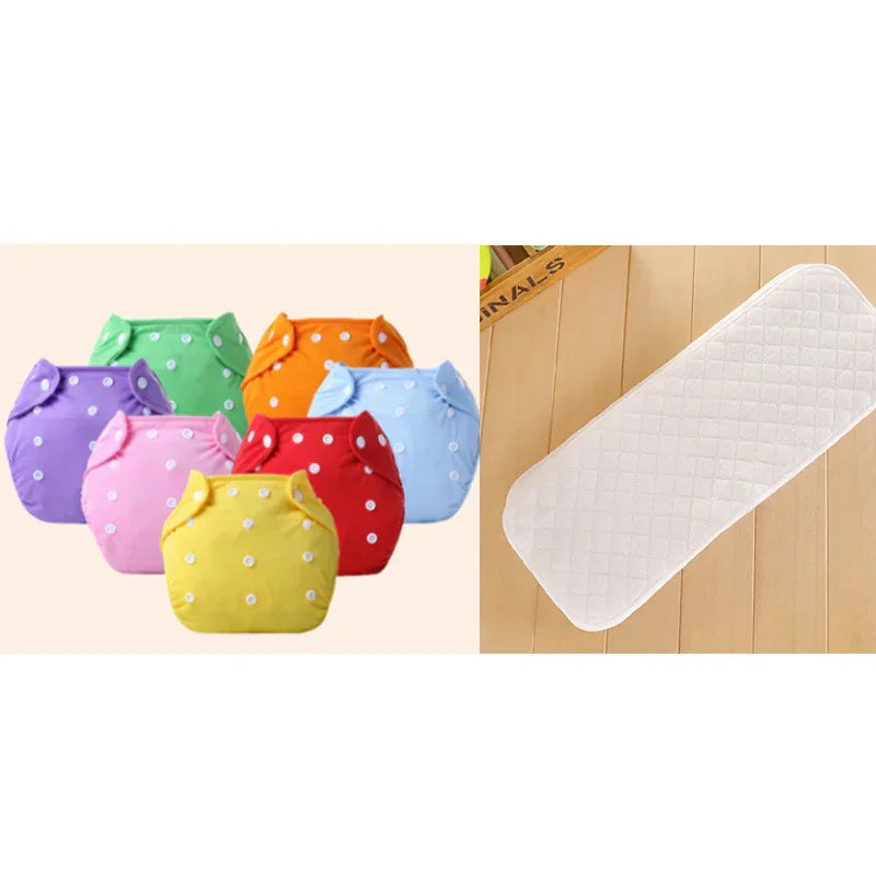 Colorful reusable cloth diapers with white snap buttons and a white quilted changing mat on wooden floor