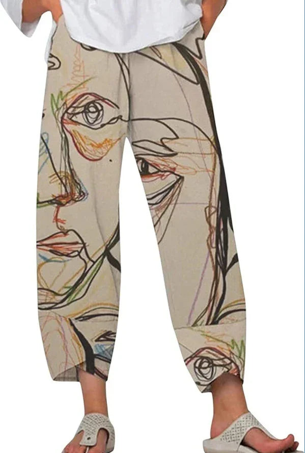 Beige pants with abstract continuous line art faces print worn with white top and sandals