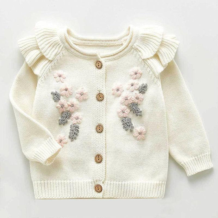 Cream-colored baby cardigan with ruffled shoulders, pink flower and gray leaf embroidery, and wooden buttons