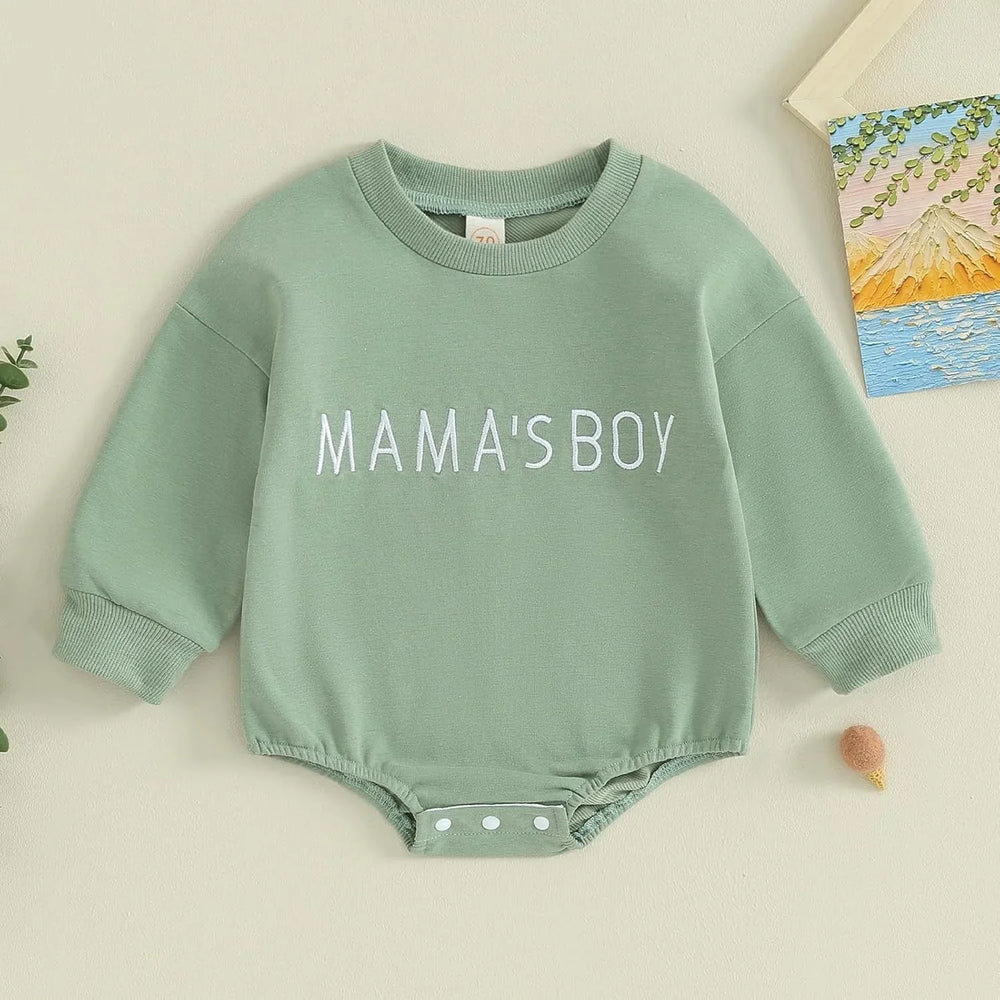 Green baby bodysuit with long sleeves and white text reading MAMA'S BOY on chest