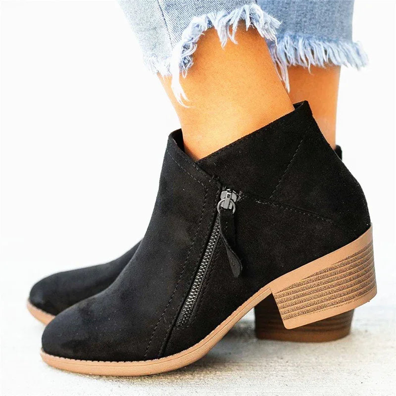 Black suede ankle boots with side zipper and stacked wooden heel worn with frayed hem light blue jeans