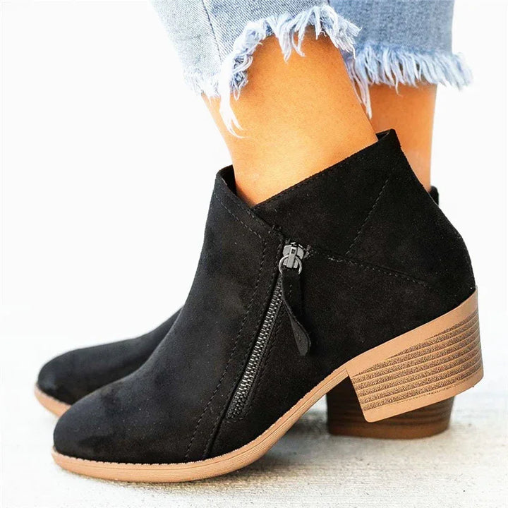 Black suede ankle boots with side zipper and stacked wooden heel worn with frayed hem light blue jeans