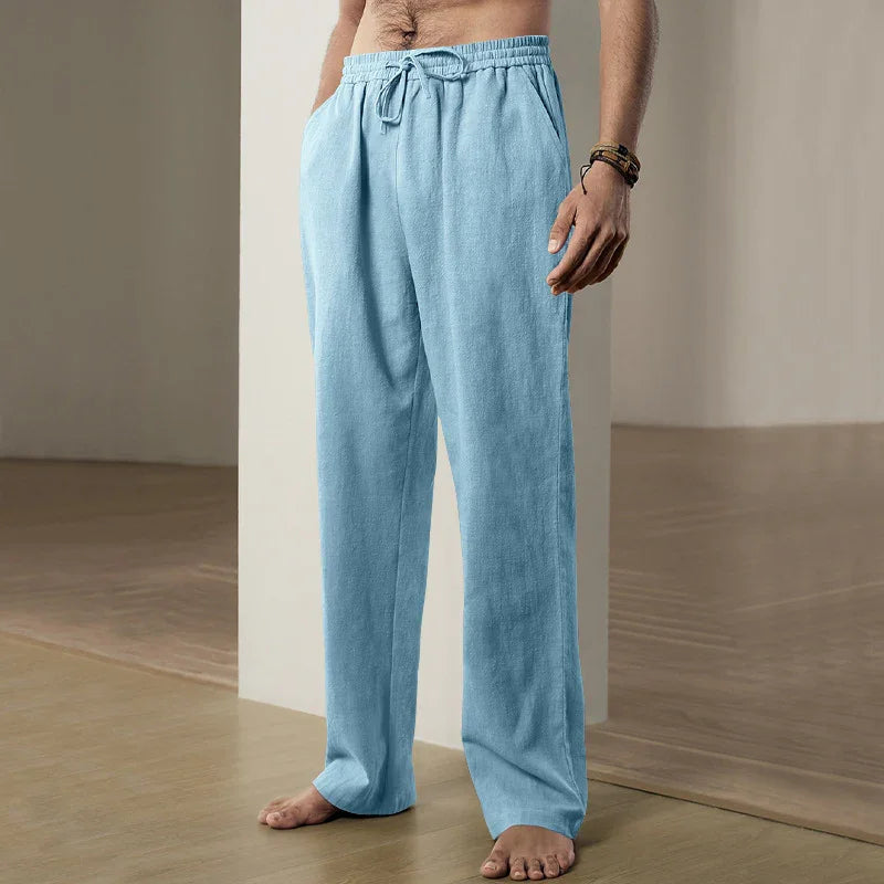 Men's light blue elastic waist drawstring lounge pants on a barefoot model indoors