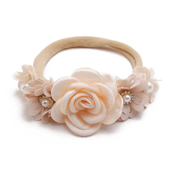 Beige floral baby headband with fabric rose and pearl rhinestone accents on white background