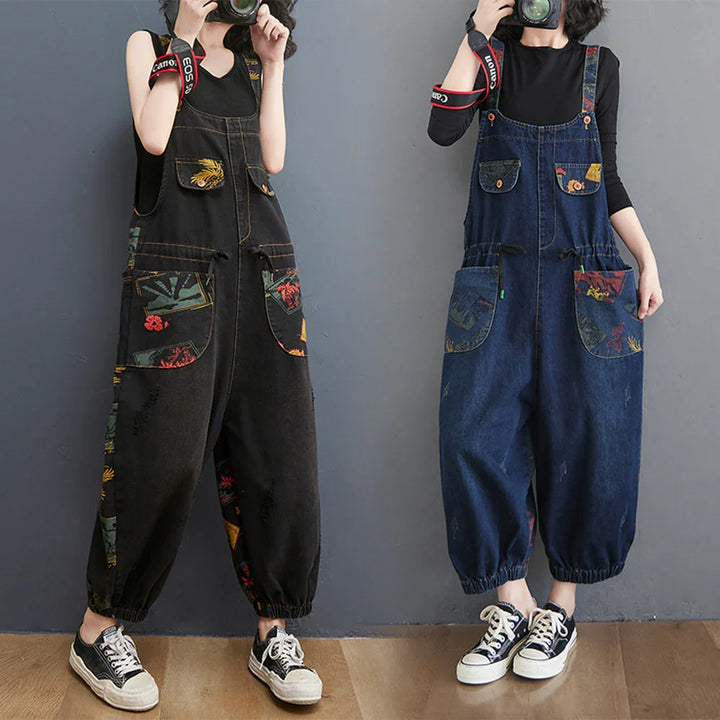 Women wearing loose denim overalls with floral patch pockets and elastic cuffs, holding cameras