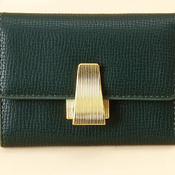 Dark green textured leather wallet with a vertical gold metal clasp on beige background