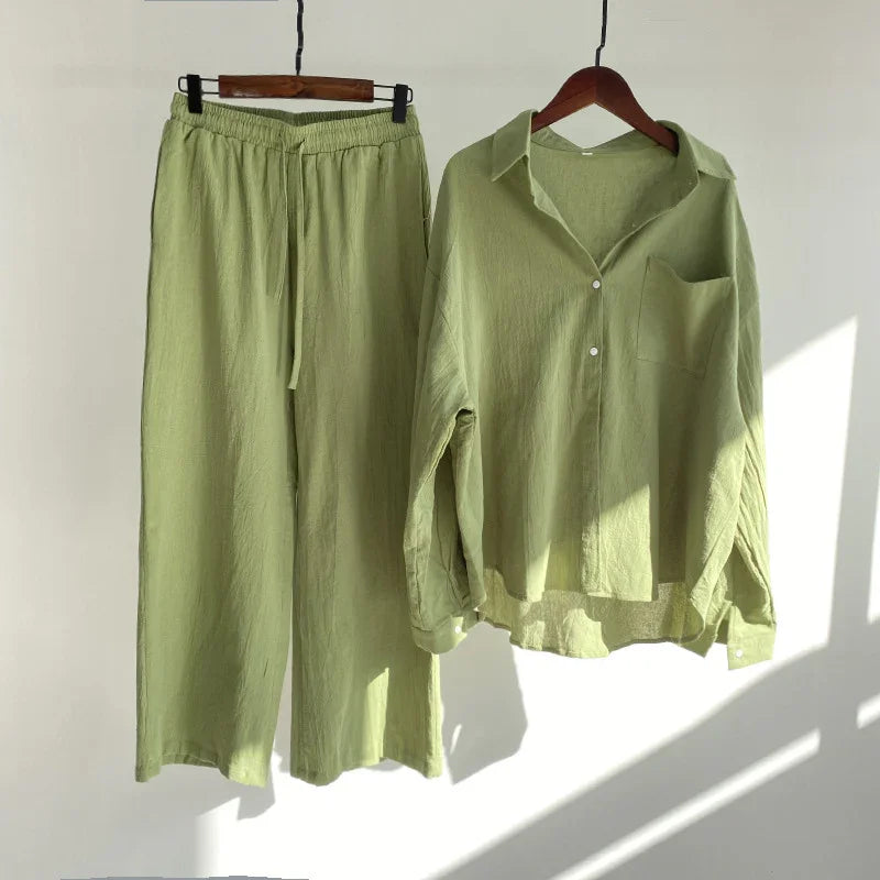 Light green women's linen pants with elastic waist and matching long-sleeve button-up shirt on hangers