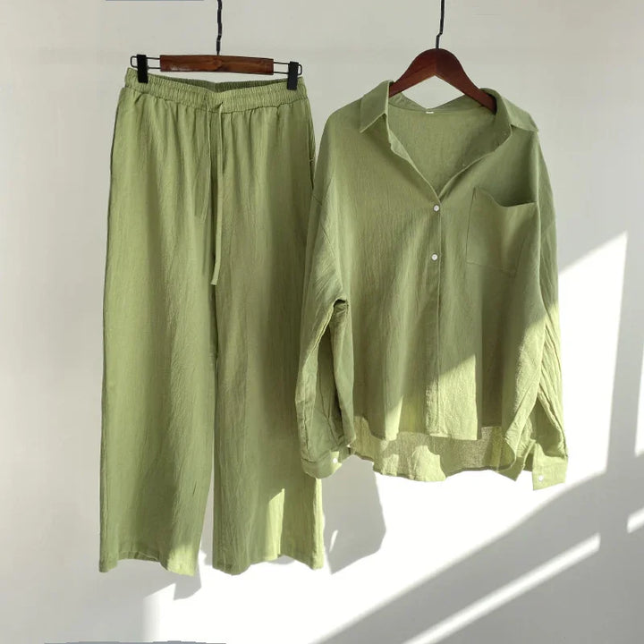 Light green women's linen pants with elastic waist and matching long-sleeve button-up shirt on hangers