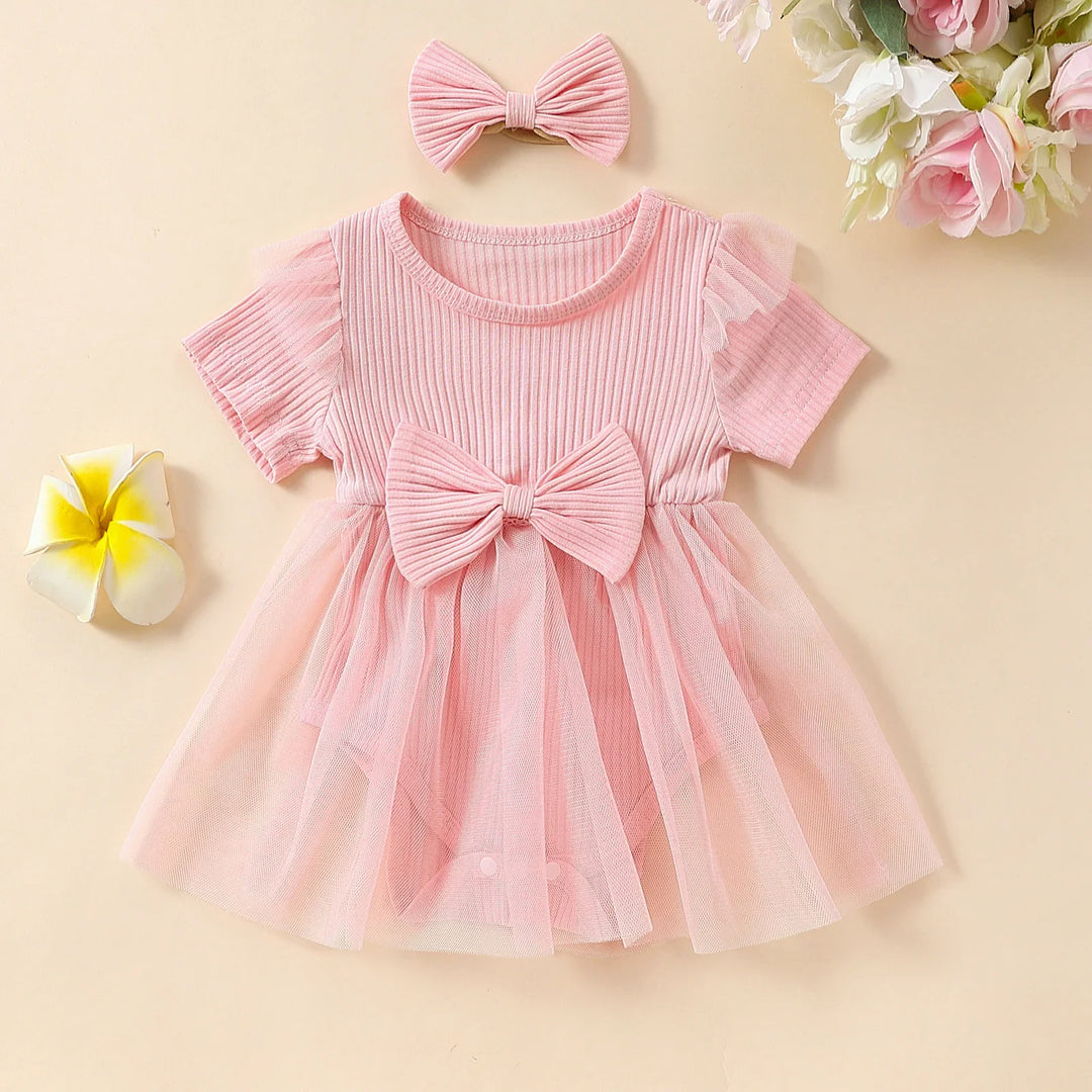 Pink baby girl dress with large bow and tulle skirt, matching pink bow headband, floral decor