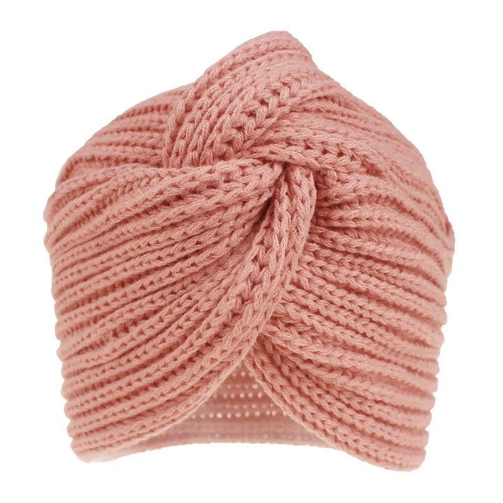 Pink knitted turban-style headband with twisted knot design and ribbed texture
