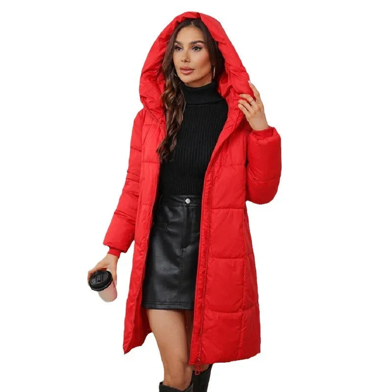 Woman wearing a red hooded puffer coat over black turtleneck and leather skirt holding a coffee cup