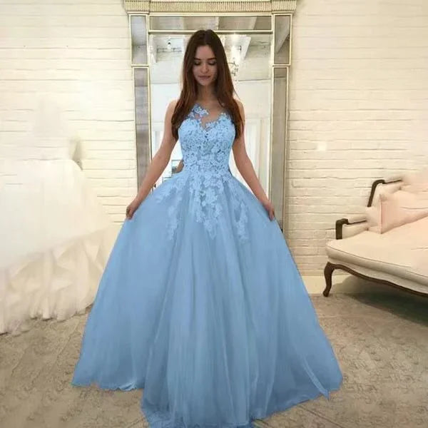 woman in elegant light blue lace ball gown standing in chic room with large mirror and vintage sofa