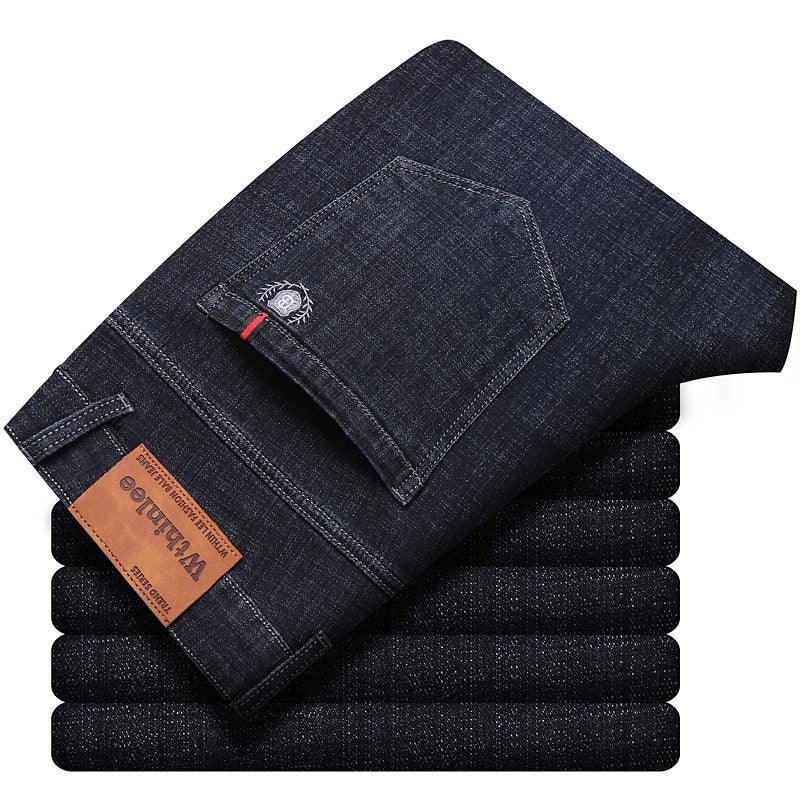 Stack of dark blue denim jeans with leather brand patch and detailed back pocket stitching