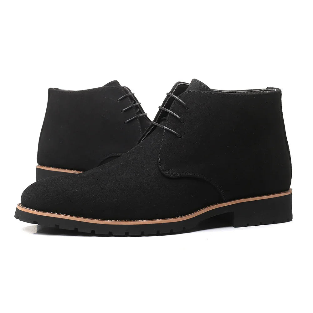 Black suede chukka boots with lace-up design and brown sole on white background