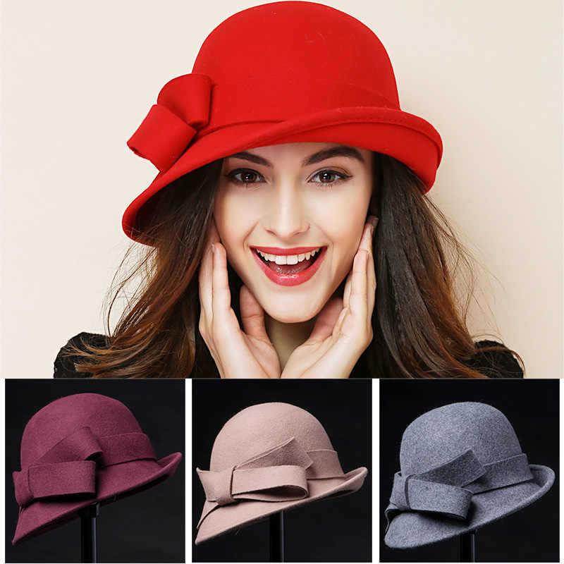 Woman wearing red cloche hat with bow, plus burgundy, beige, and gray cloche hats on display