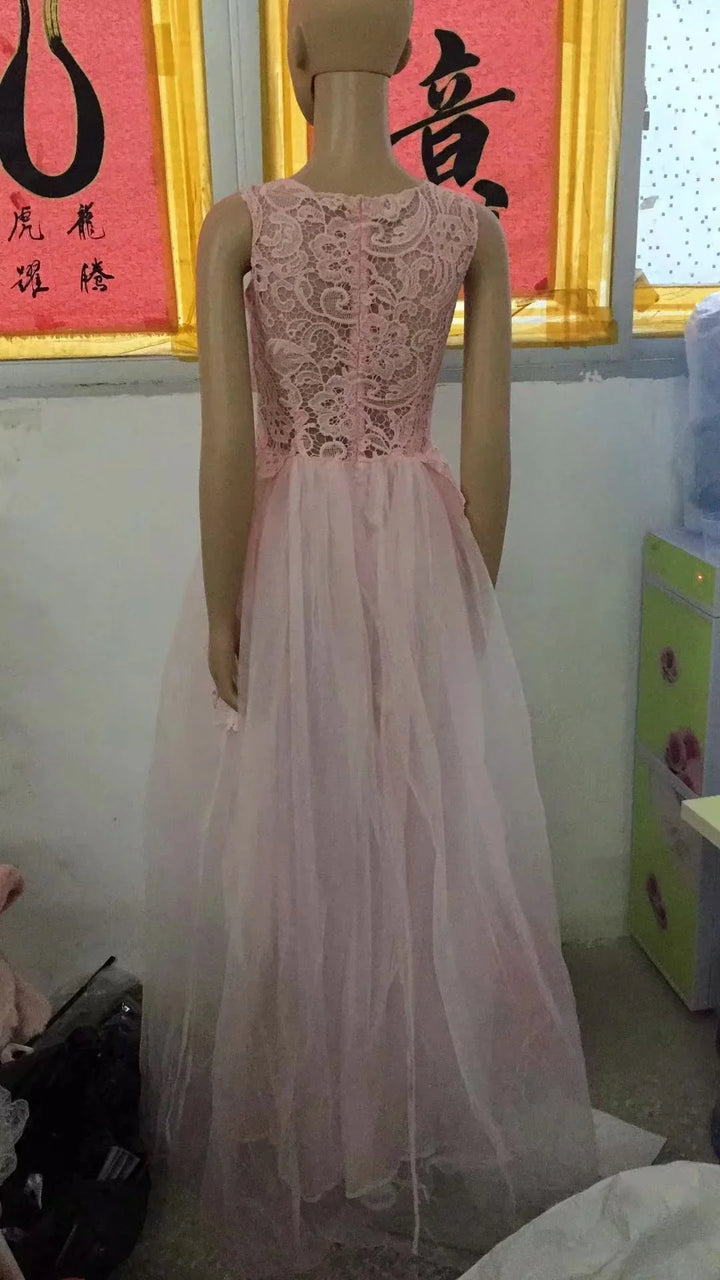 Back view of mannequin wearing a pink lace top and tulle long skirt dress in a room with Chinese calligraphy art