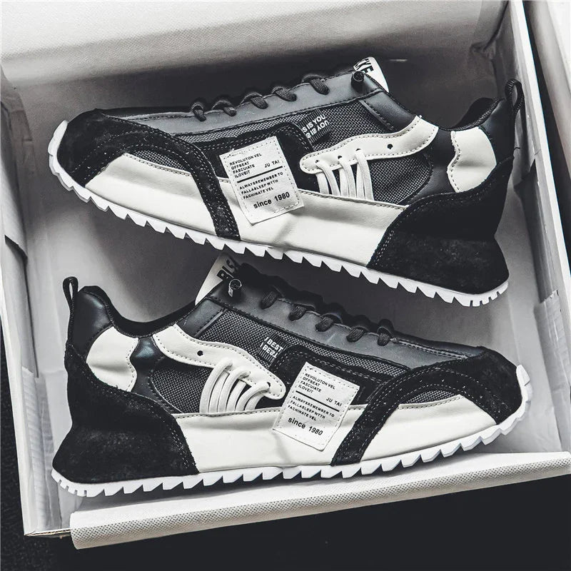 Pair of black and white casual sneakers with mesh and leather details in a shoebox