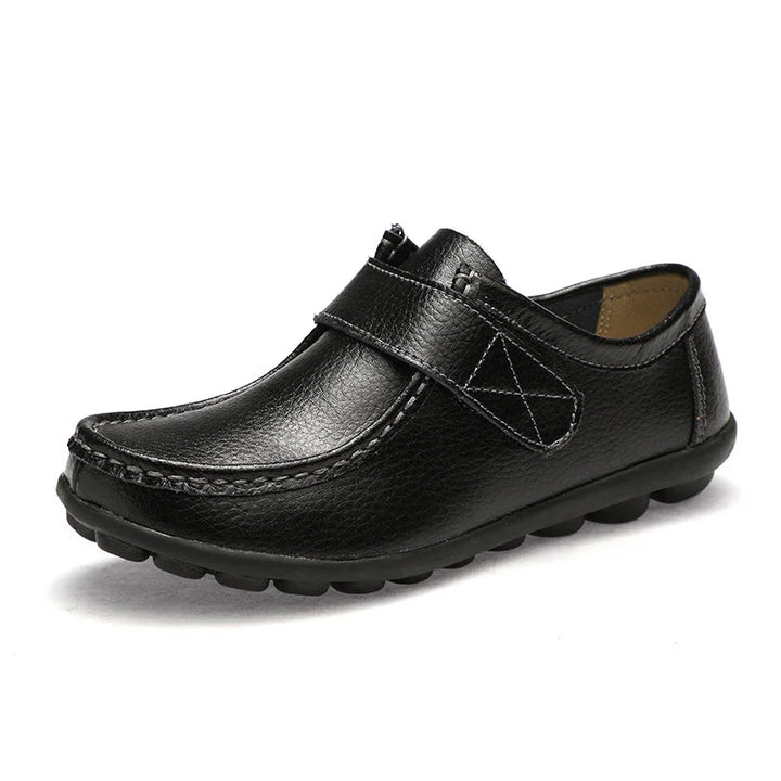 Black leather men's casual loafer with velcro strap and textured sole on white background