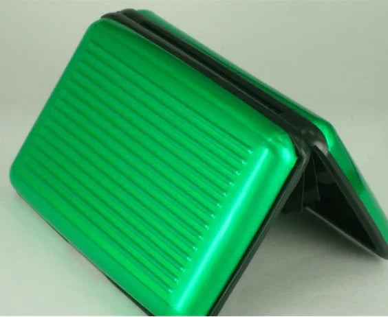 Green hard-shell wallet or cardholder with black edges and ridged surface, open and standing upright