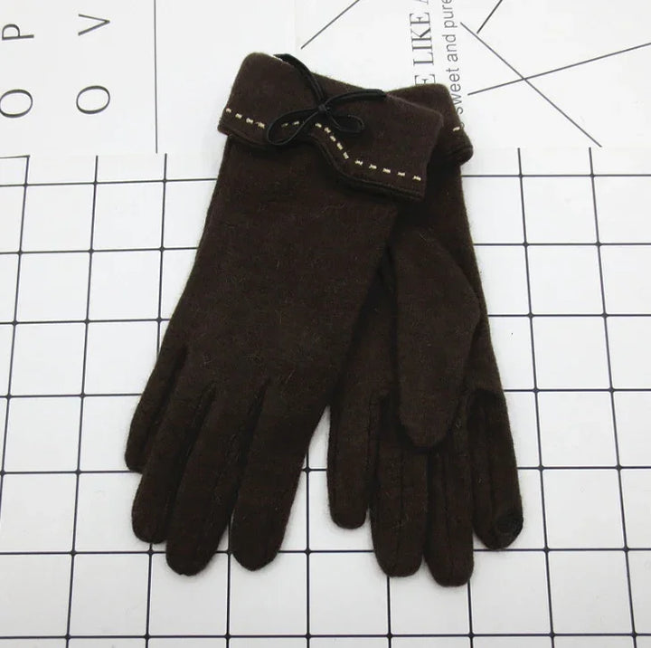 Pair of dark brown wool winter gloves with small bow and stitching detail on cuff