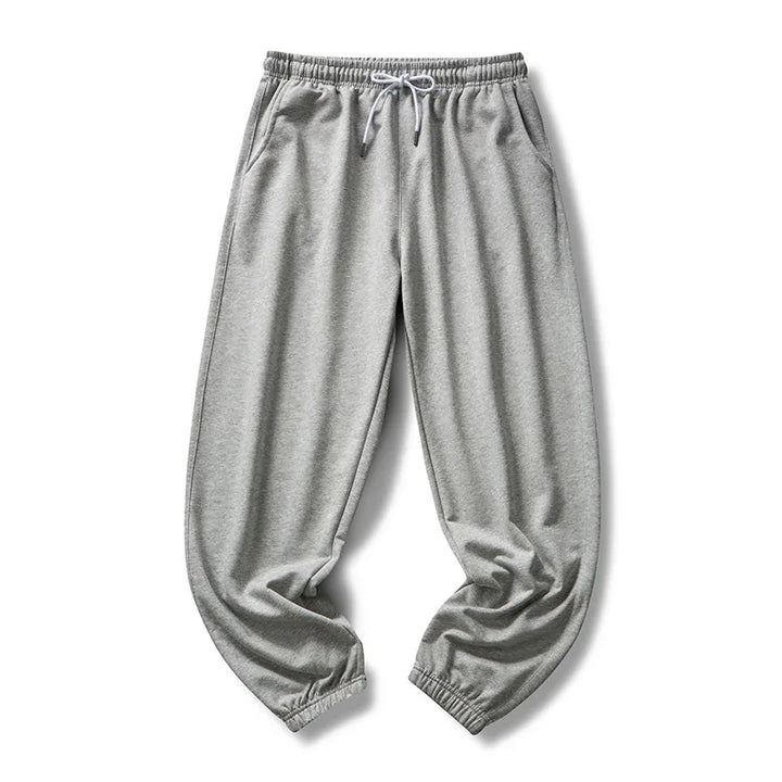 Light gray sweatpants with elastic waistband, drawstring, side pockets, and cuffed ankles