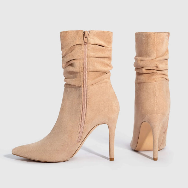 Pair of beige suede high heel ankle boots with slouchy design and side zippers