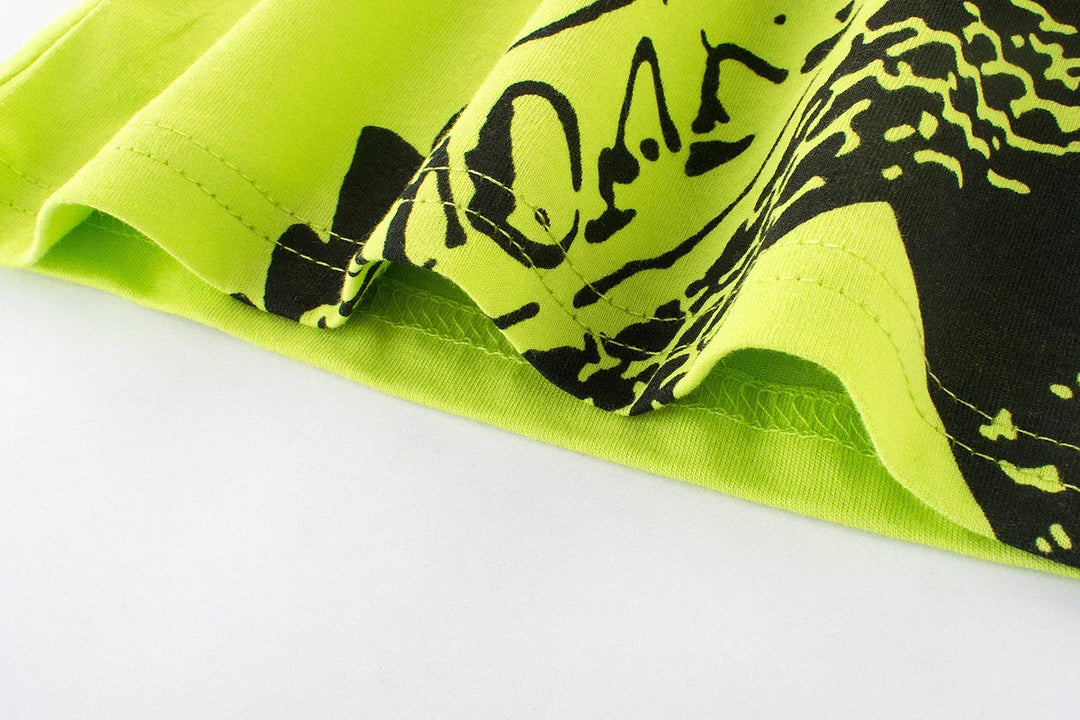 Close-up of neon green fabric with black print and detailed stitching on white background