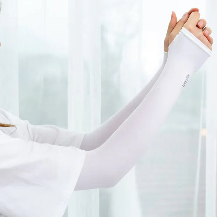 Person wearing white UV protection arm sleeves with thumb holes against a bright window background