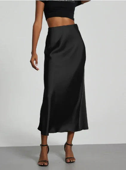 woman wearing a sleek black satin midi skirt with high waist and strappy black heels