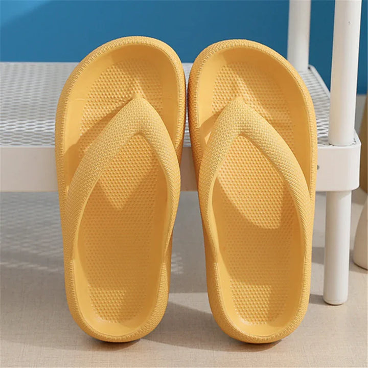 Pair of yellow textured foam flip-flops displayed on light floor with white shelving in background