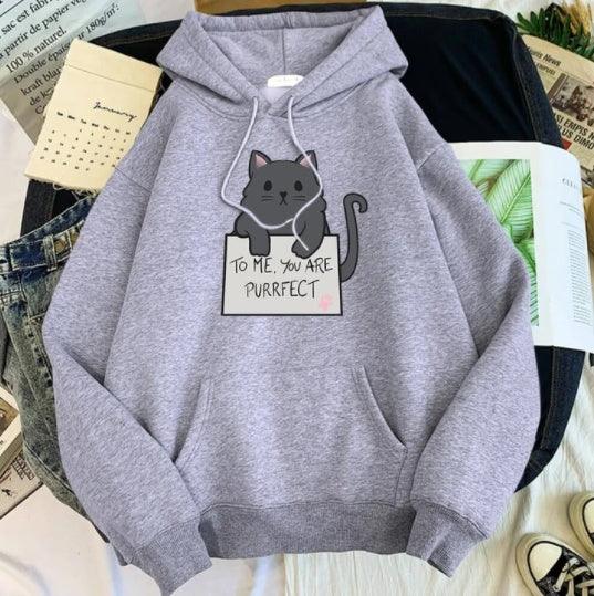 Gray hoodie with black cat graphic and text 'To me, you are purrfect', casual laid flat with jeans and books