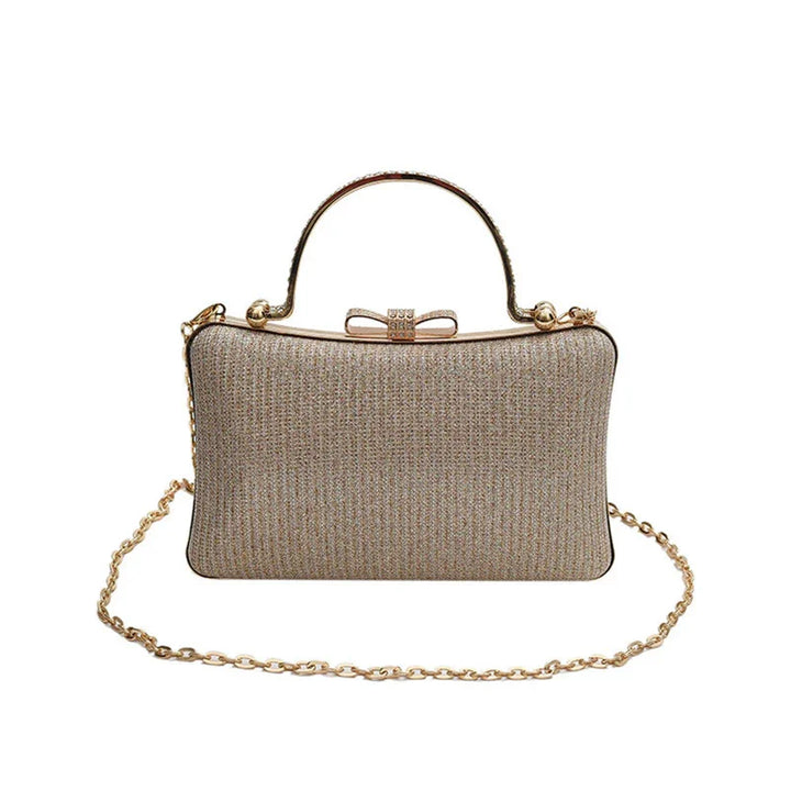 Elegant gold clutch bag with glitter texture, top handle, bow clasp, and gold chain strap