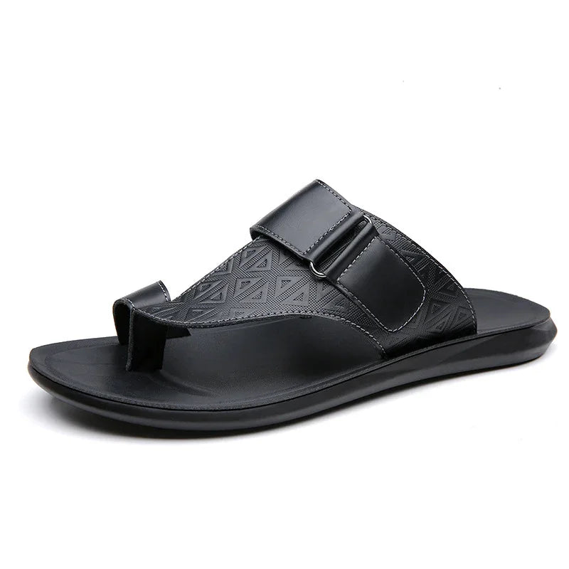 Black men's leather toe-loop sandal with textured strap and adjustable buckle on white background