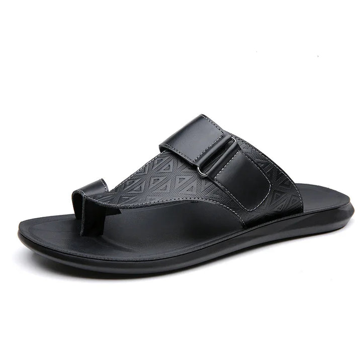 Black men's leather toe-loop sandal with textured strap and adjustable buckle on white background